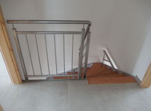 Gewendelte Treppe mit Holzstufen und Stabgeländer
